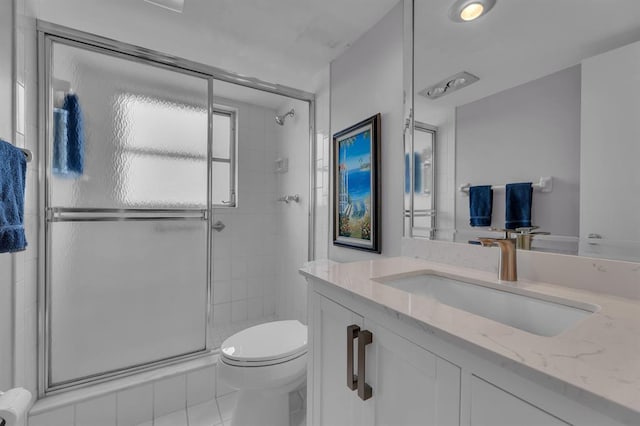 bathroom featuring toilet, walk in shower, vanity, and tile patterned floors