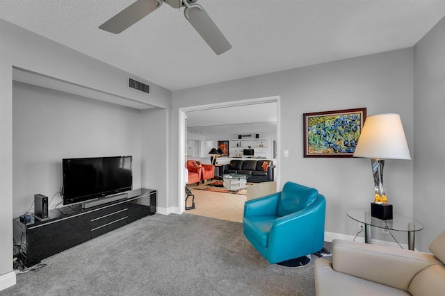 carpeted living room with ceiling fan and a textured ceiling