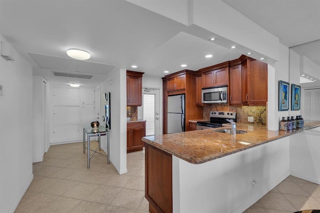 kitchen with light stone countertops, appliances with stainless steel finishes, backsplash, kitchen peninsula, and light tile patterned floors