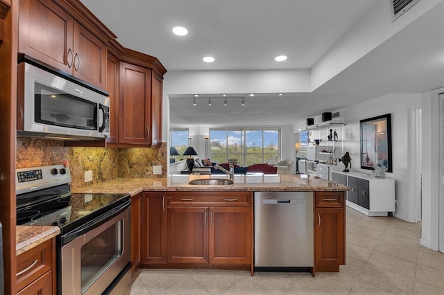 kitchen with kitchen peninsula, stainless steel appliances, sink, light tile patterned floors, and tasteful backsplash