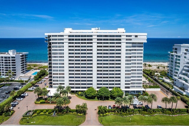 view of building exterior with a water view and a beach view