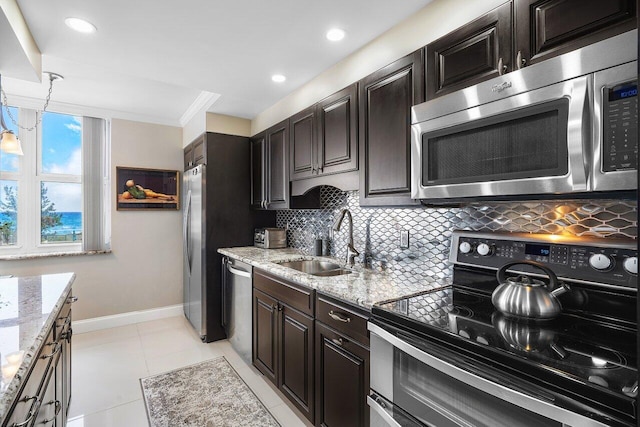 kitchen featuring appliances with stainless steel finishes, sink, backsplash, crown molding, and light stone countertops