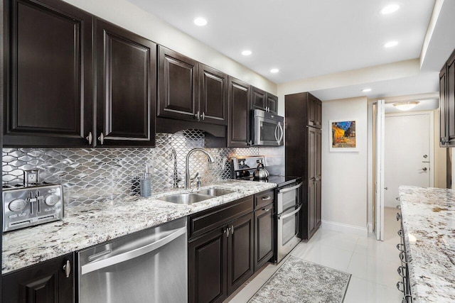 kitchen featuring sink, light tile patterned floors, backsplash, stainless steel appliances, and light stone countertops