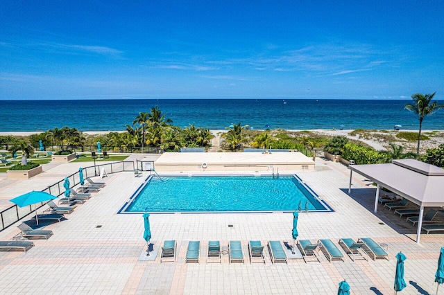 view of swimming pool featuring a patio and a water view