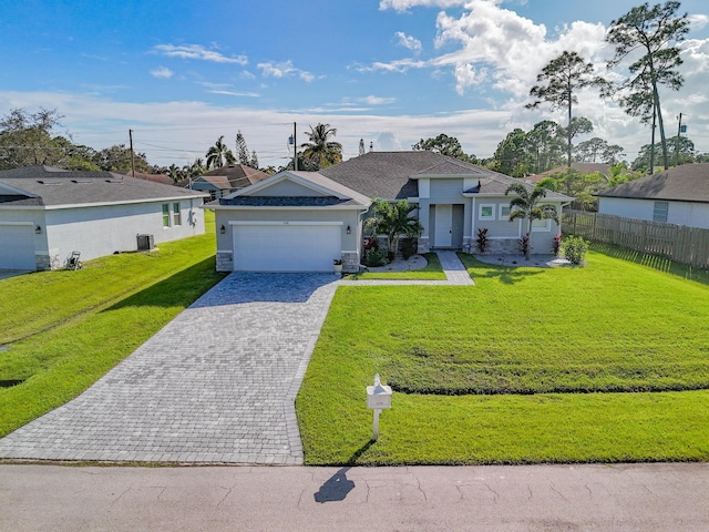 single story home with decorative driveway, fence, a front yard, a garage, and central AC unit