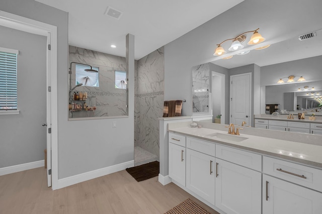 bathroom with vanity, hardwood / wood-style flooring, and a tile shower