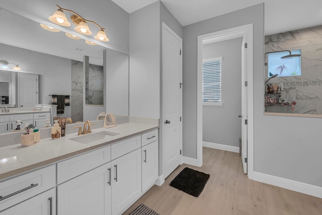 bathroom featuring vanity, wood-type flooring, and a tile shower