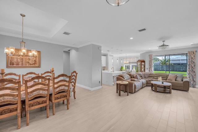 dining room featuring a notable chandelier, crown molding, and light hardwood / wood-style flooring