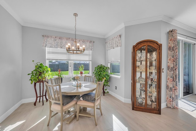 dining room featuring light wood-type flooring, a notable chandelier, and crown molding