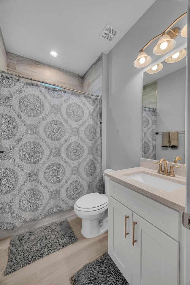 bathroom featuring toilet, a shower with curtain, vanity, and hardwood / wood-style flooring