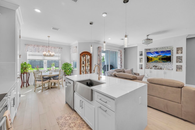 kitchen with light hardwood / wood-style floors, stainless steel appliances, white cabinets, a kitchen island with sink, and pendant lighting