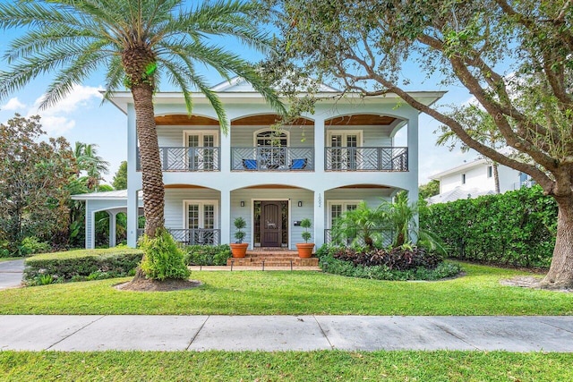 view of front of property featuring a porch, a balcony, and a front lawn