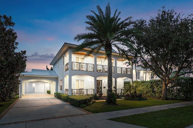 view of front of property featuring a lawn and a balcony