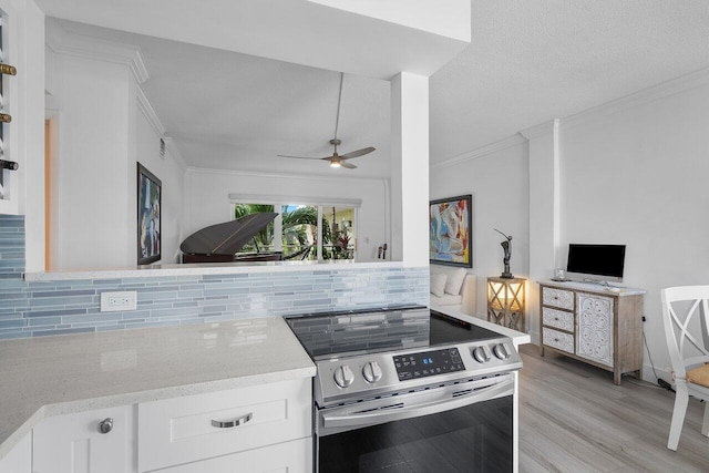 kitchen featuring white cabinets, decorative backsplash, stainless steel range with electric cooktop, and light hardwood / wood-style floors