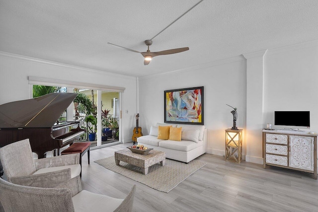 living room with ceiling fan, ornamental molding, a textured ceiling, and light wood-type flooring