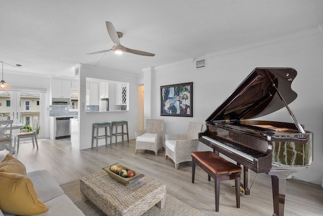 living area featuring crown molding, light hardwood / wood-style flooring, and ceiling fan