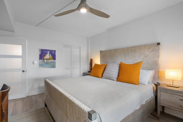 bedroom with a closet, hardwood / wood-style flooring, and ceiling fan