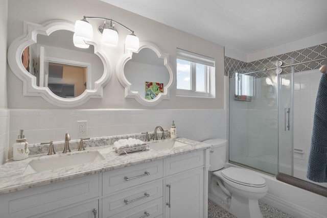 full bathroom with vanity, enclosed tub / shower combo, tile walls, and toilet