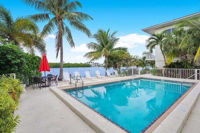 view of swimming pool with a patio and a water view