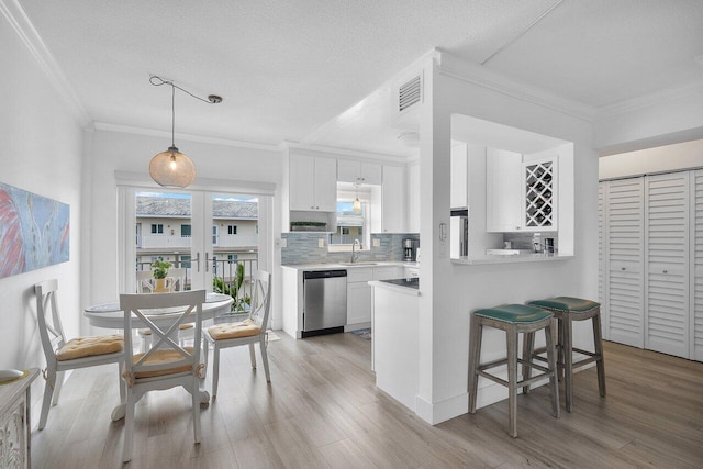 kitchen with white cabinetry, dishwasher, sink, and light wood-type flooring