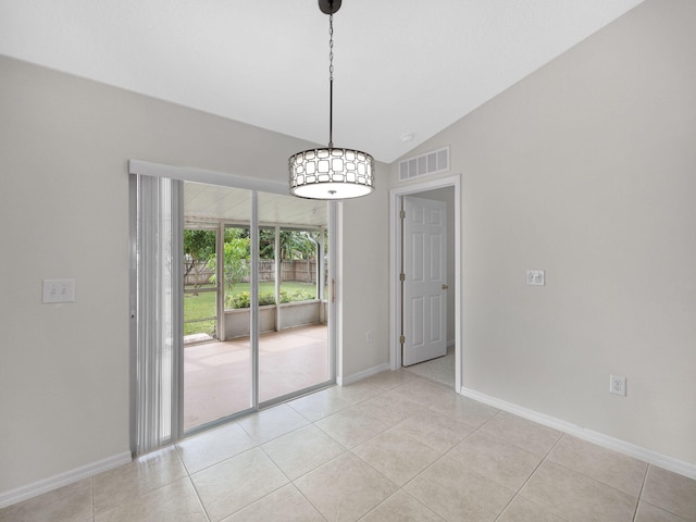 unfurnished dining area featuring vaulted ceiling and light tile patterned flooring