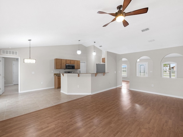 unfurnished living room with light hardwood / wood-style flooring, lofted ceiling, and ceiling fan