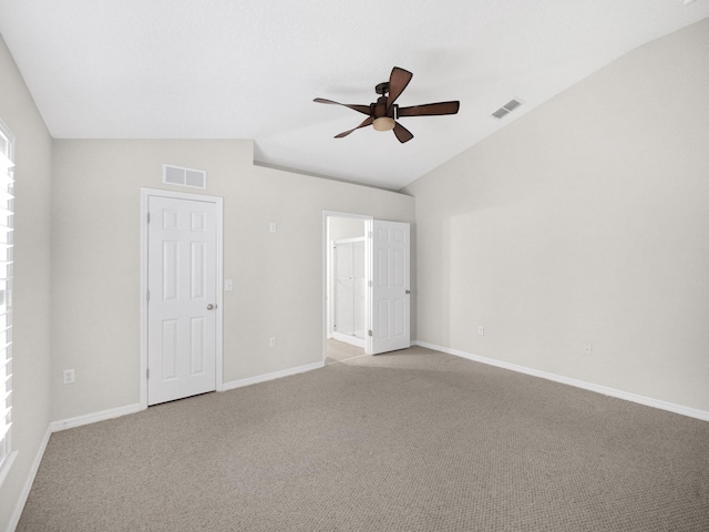 carpeted spare room featuring ceiling fan and vaulted ceiling