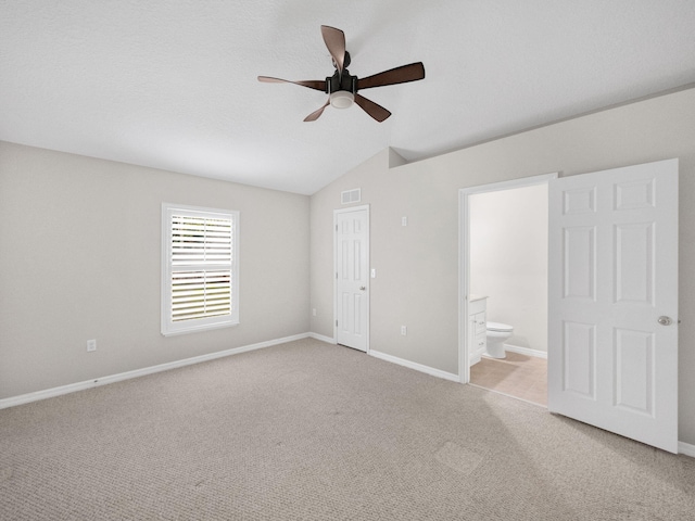 unfurnished bedroom with light carpet, lofted ceiling, ceiling fan, ensuite bathroom, and a closet