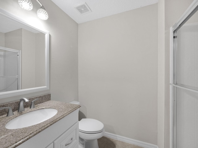 bathroom with tile patterned floors, toilet, a shower with shower door, vanity, and a textured ceiling