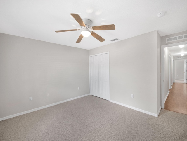 unfurnished bedroom with carpet, a closet, and ceiling fan