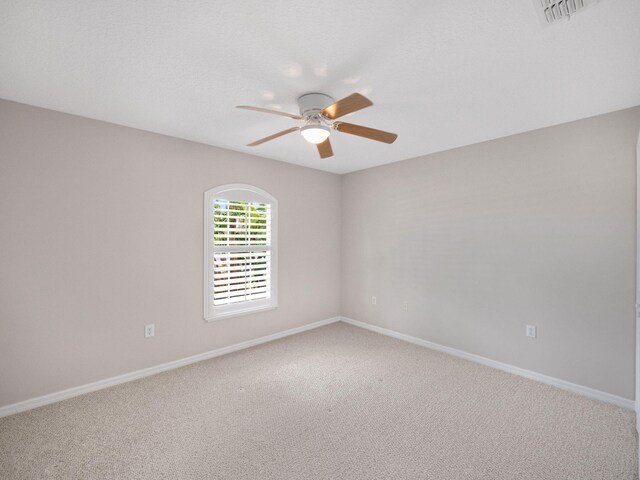 spare room with ceiling fan and carpet