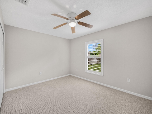 empty room with carpet floors, a textured ceiling, and ceiling fan