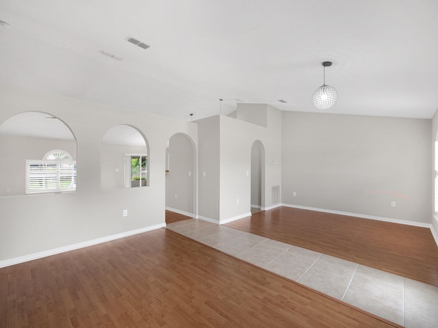 spare room with vaulted ceiling and hardwood / wood-style floors