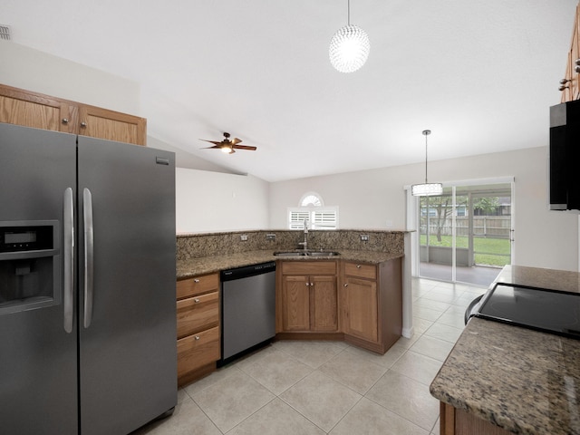 kitchen with appliances with stainless steel finishes, sink, hanging light fixtures, and vaulted ceiling