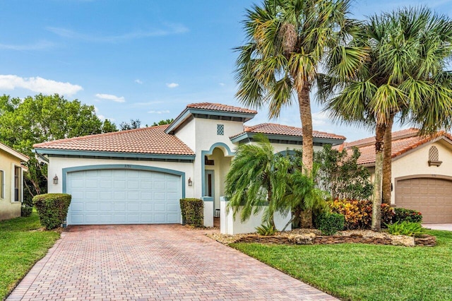 mediterranean / spanish home featuring a garage and a front lawn