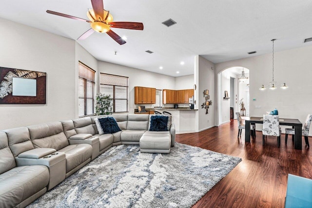 living room with dark hardwood / wood-style floors and ceiling fan with notable chandelier