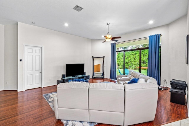 living room with ceiling fan, dark hardwood / wood-style flooring, and a textured ceiling