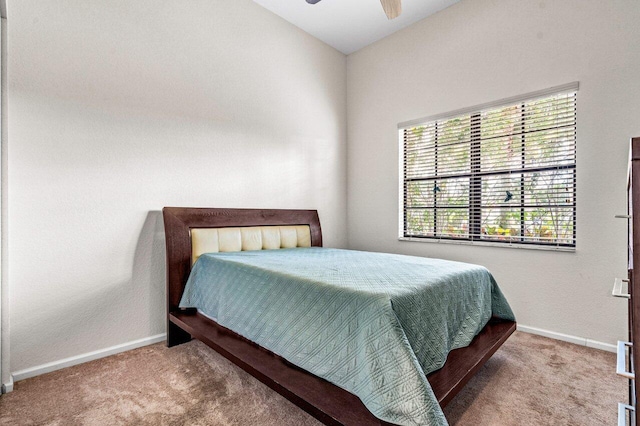 carpeted bedroom featuring ceiling fan and vaulted ceiling