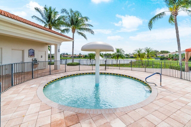 view of swimming pool with a patio area and a water view