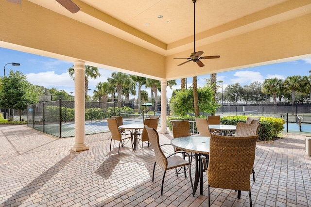 view of patio / terrace with ceiling fan and tennis court