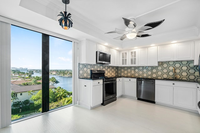 kitchen with tasteful backsplash, white cabinetry, a water view, and appliances with stainless steel finishes