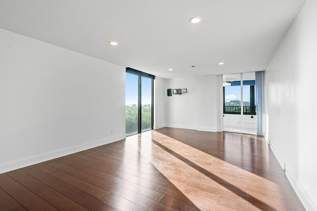 spare room featuring floor to ceiling windows and dark wood-type flooring