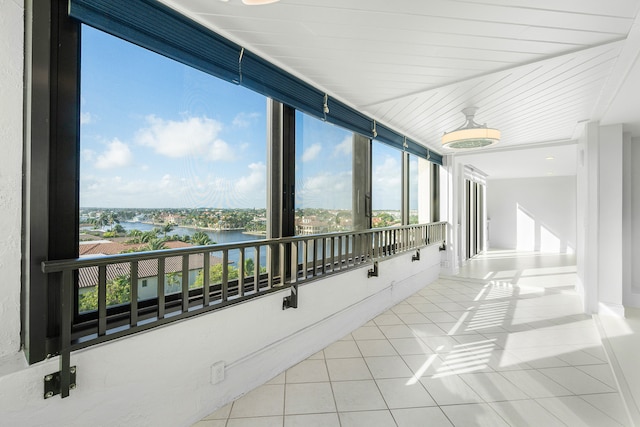 sunroom featuring a water view