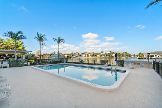 view of pool featuring a water view and a patio