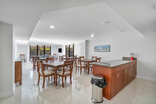 dining room featuring crown molding and light tile patterned floors