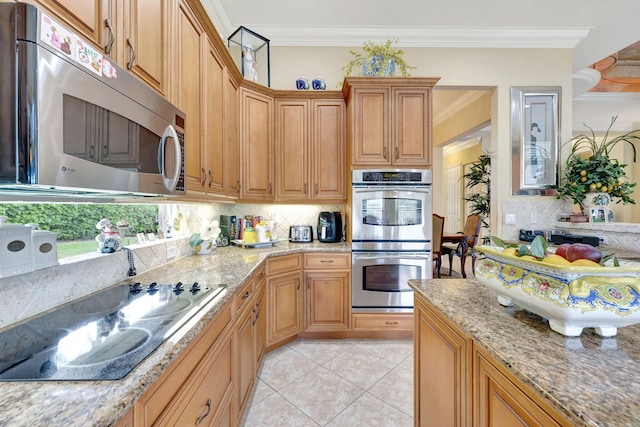 kitchen featuring decorative backsplash, light tile patterned floors, appliances with stainless steel finishes, crown molding, and light stone counters