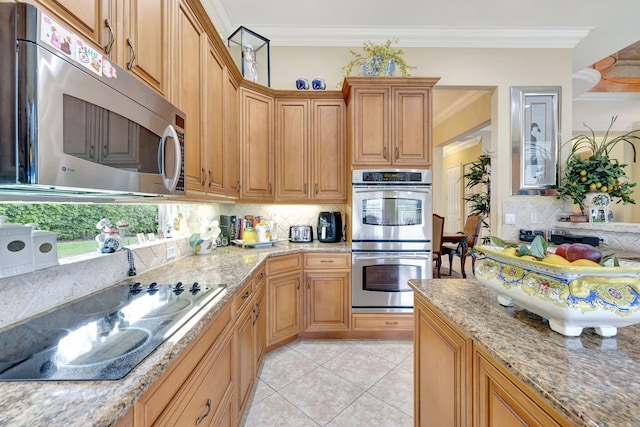 kitchen with stainless steel appliances, backsplash, light stone countertops, ornamental molding, and light tile patterned floors