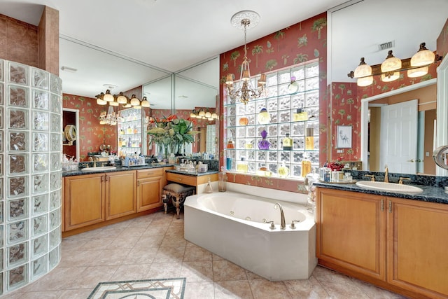 bathroom with wallpapered walls, a chandelier, a jetted tub, and two vanities