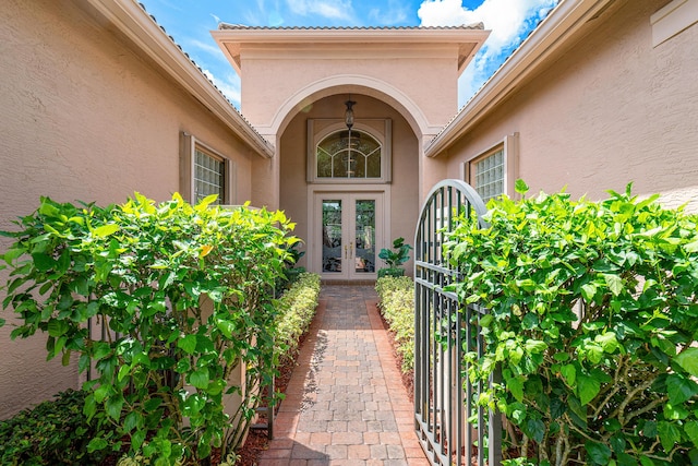 entrance to property featuring french doors and stucco siding