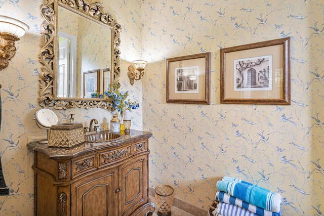 bathroom featuring wallpapered walls and vanity